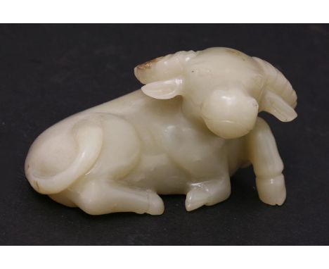 A jade water Buffalo, 19th/20th century, recumbent, its tail resting on its back, one leg raised, the stone pale-grey with sm