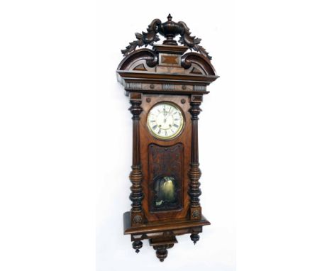 Walnut Vienna regulator two train wall clock, the 7" cream dial within a pillared carved case with pendulum window, 56" high 