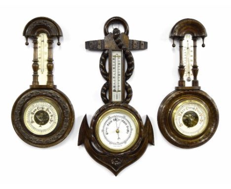 Barometer/thermometer within a carved oak case in the form of an anchor, 22" high; also two similar cased barometer/thermomet
