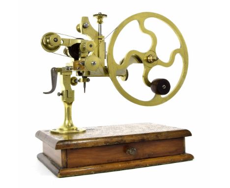 Good early brass wheel cutting tool, upon a rectangular oak base fitted with a drawer containing accessories, 11.5" wide over