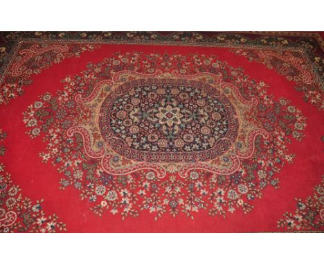 A Persian design red ground carpet woven central floral medallion, 330 x 240cm