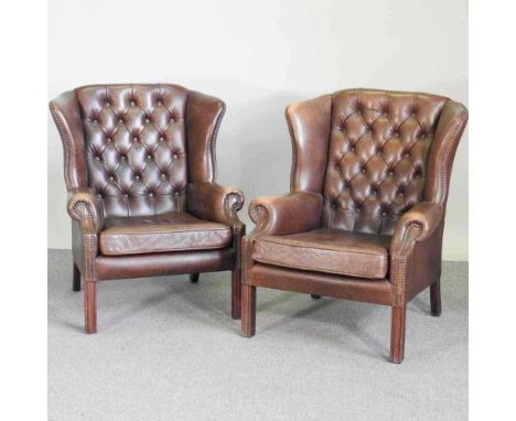 A pair of brown leather upholstered wing armchairs, each with a button back, on square moulded legs (2)Overall condition is s