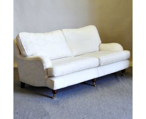 A cream damask upholstered sofa, on turned legs and brass castors187w x 94d x 80h cm
