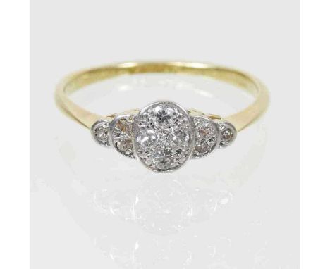 An 18 carat gold platinum set diamond cluster ring, of stepped design, 2g. size N