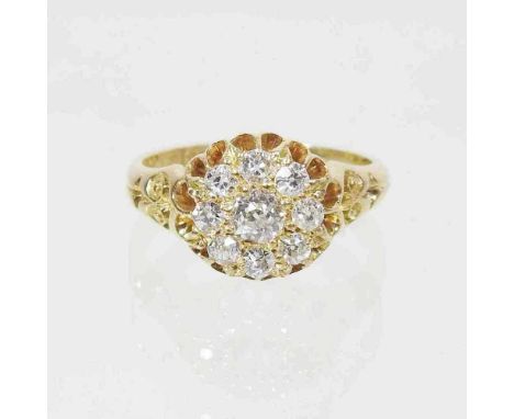 An 18 carat gold diamond cluster ring, the central diamond, set within a graduated row of eight further diamonds, with textur