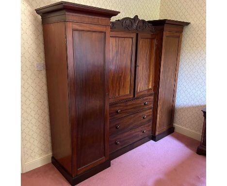 A large Victorian mahogany inverted breakfront triple wardrobe, with a moulded cornice, on a plinth base