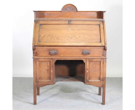An Arts and Crafts light oak bureau, with a shaped gallery back95w x 45d x 130h cm