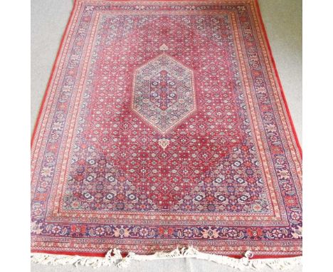 A Persian rug, with a central medallion and all over designs, on a red ground, 200 x 306cm