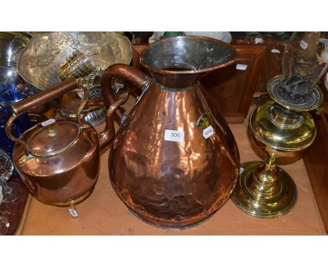 A large copper measure, together with a copper kettle on brass stand and an early 20th century oil lamp (4)