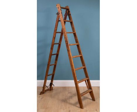 An old pitch pine extending ladder46cm wide at the base x 210cm highQty: 1In used condition with signs of old decorators pain