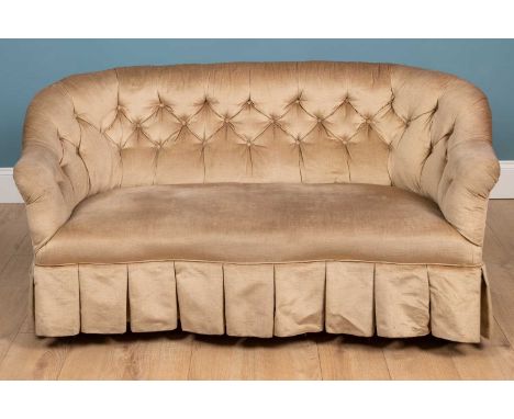 A Victorian small button back upholstered sofa with serpentine front and standing on turned tapering walnut front legs termin