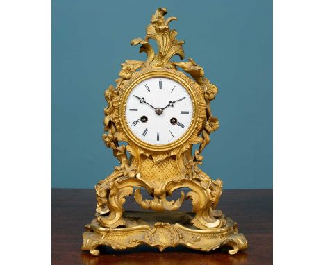 A 19th century French ormolu mantel clock with enamel dial the movement striking the hours on a bell and with silk suspension