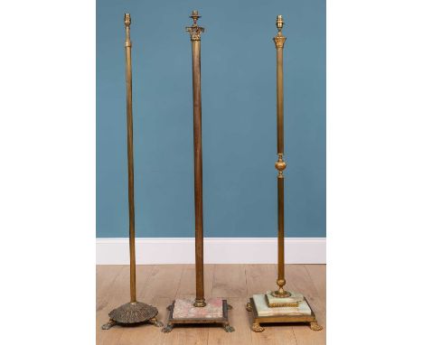 An Italian brass standard lamp of Corinthian column form on a stepped onyx base with paw feet; and two further similar standa