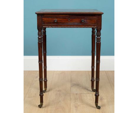 A Regency rosewood small table with faux drawer to one side and frieze drawer to the other, all on ring turned legs terminati