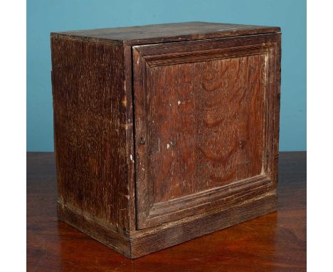 A 17th or 18th century oak spice cabinet, the panelled door opening to reveal various drawers within30.5cm wide x 20cm deep x