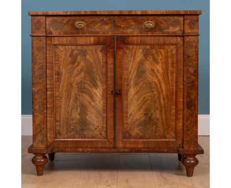 A Regency mahogany side cabinet by Peter Cundry, with a frieze drawer and twin panelled doors enclosing a shelf within, all o