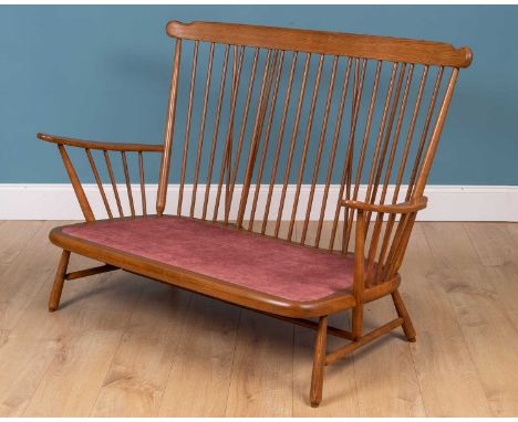 A contemporary Ercol ash two seater sofa with spindle back137cm wide x 70cm deep x 98cm highQty: 1In good condition with new 