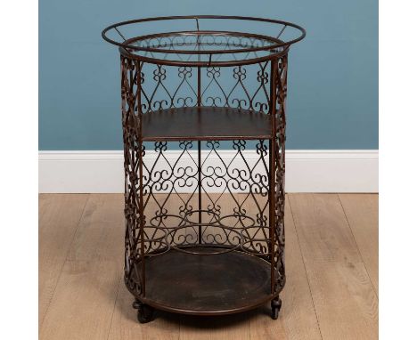 A circular brown painted wrought iron drinks trolley, with glass inset top, a shelf and bottle racks beneath and on castors56