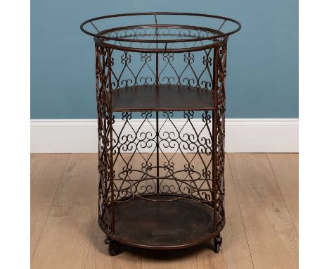 A circular brown painted wrought iron drinks trolley, with glass inset top, a shelf and bottle racks beneath and on castors56