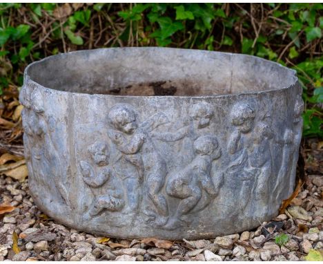 A cylindrical lead garden planter decorated with puttiapproximately 46cm diameter x 20cm highQty: 1In weathered and worn cond