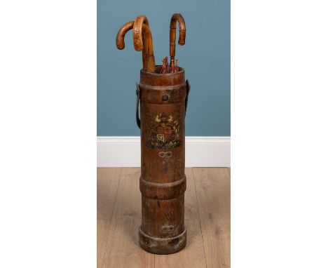 An early 20th century stick stand constructed from a leather and canvas cordite case with coat of arms and strap handle, comp