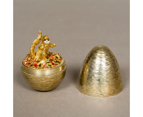 A Stuart Devlin silver gilt novelty egg, hallmarked London 1987, number to the underside 18Enclosing a squirrel holding a flo