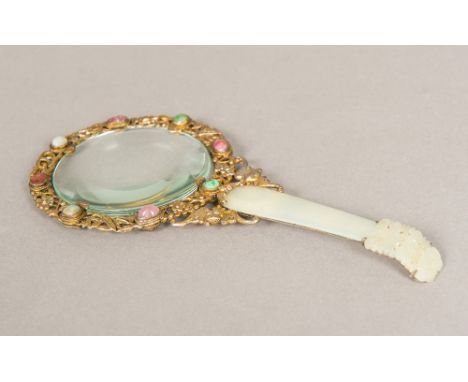 A Chinese jade handled magnifying glassOf pierced form, decorated with bats and floral sprays set with cabochon stones.  19 c