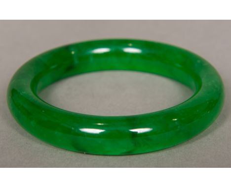A Chinese carved spinach jade bangle8.5 cm diameter.  CONDITION REPORTS: Generally good, expected wear. 