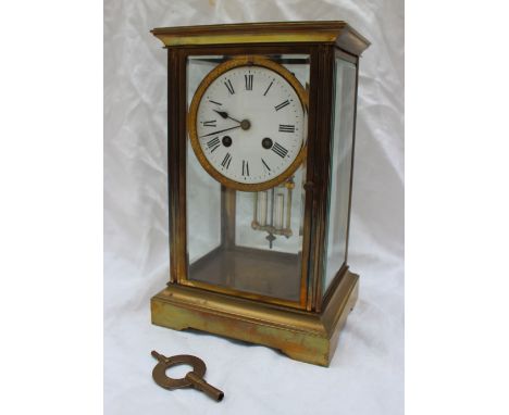 A brass four glass mantle clock, the circular enamel with Roman numerals, striking on a bell with a faux mercury pendulum, 27