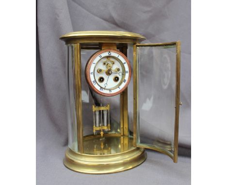 A late 19th / early 20th century oval brass four glass mantle clock the circular dial with Roman numerals, insight movement,s