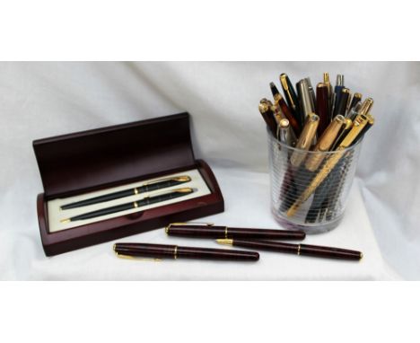 A Parker Sonnet red lacquer fountain pen, together with two matching roller ball pens and a collection of Parker pens