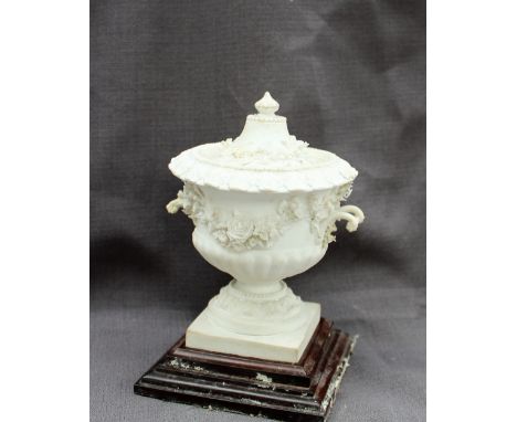 A Swansea porcelain urn and cover, heavily encrusted with flower heads and leaves, on a square base, 15cms high CONDITION REP