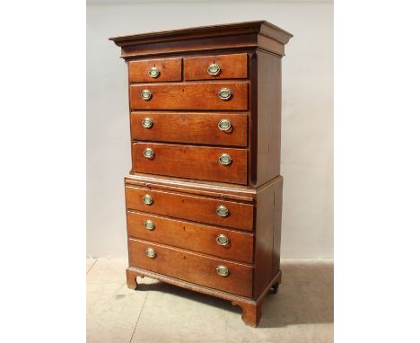 An 18th century oak chest on chest, the moulded cornice above two short and three long drawers on bracket feet, the oval bras