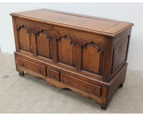 An 18th century oak mule chest, the rectangular later hinged top above four ogee panels and three drawers on shaped bracket f