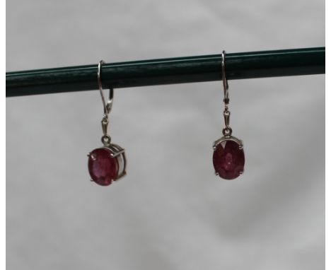 A pair of 18ct white gold and ruby drop earrings, the oval faceted rubies measuring 11 x 9mm