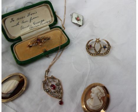 An Edwardian double crescent brooch set with seed pearls and three stars set with a ruby, sapphire and a diamond to a yellow 