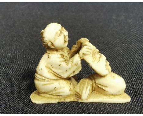 FEINE NETSUKE: MANN MIT MASKE, Japan, Bein, partiell geschwärzt. Feine, detailreich gearbeitete Netsuke, ohne Signatur. Vollp