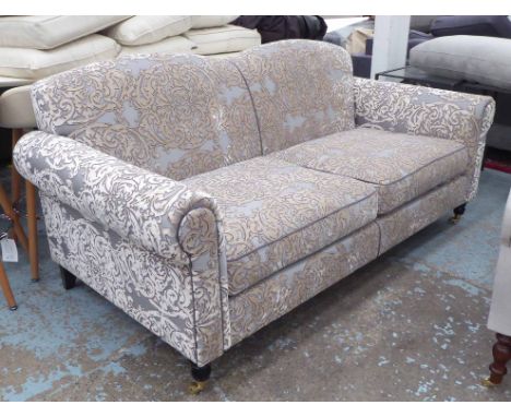 SOFA, two seater, humpback and roll arms in raised patterned upholstery on short turned legs with brass castors, 185cm L x 92