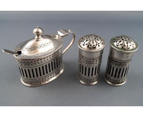 A silver three piece cruet set in the 18th century bright cut oval style, comprising a mustard pot with a domed lid set an ur