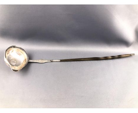 An 18th century white metal punch ladle with bead punched decorated edge/pouring lip, the oval bowl set a coin of 1736, the f