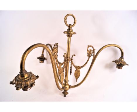 An Edwardian brass three branch ceiling light with ring top leading to a central baluster rod from which springs S scroll arm