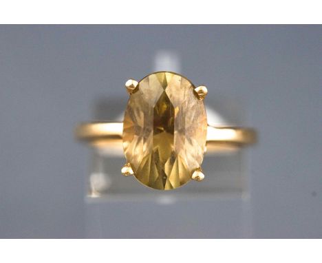 A yellow metal single stone ring. Set with a fancy faceted cut yellowish green chrysoberyl. Hallmarked 14ct gold, Birmingham.