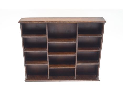 A mahogany hanging wall shelf divided with pigeon holes, 46cm high,  56cm wide, 10cm deep