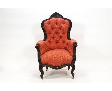 A Victorian ladies carved mahogany armchair, the back rail carved and pierced with a Rococo floral motif and deep button upho