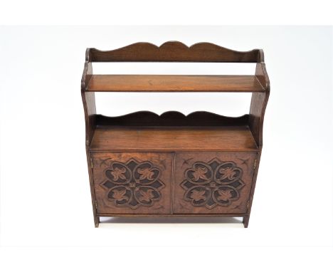 A Victorian mahogany hanging wall shelf,  with shaped crest above two shelves above two carved doors, 68cm high, 60cm wide, 1