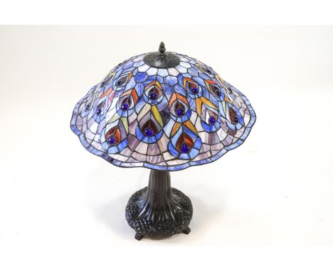 A Tiffany glass style table lamp with a peacock shade, 66cm high, 52cm wide 