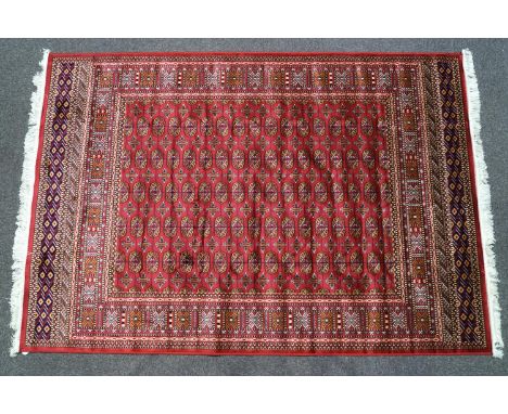 A machine woven Keishan style carpet with eleven rows of medallions on a red ground within multiple borders, 230cm x 160cm