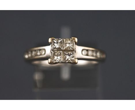 A white metal dress ring set with four princess cut diamonds together with round brilliant cut diamond shoulders. Stamped tot