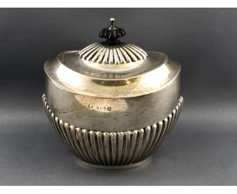 A silver tea caddy of semi fluted oval form, the hinged domed lid with an ebony finial, Birmingham 1912, 12cm high, 165grams