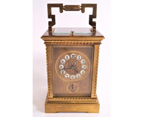 A 19th century gilt and four glass carriage clock with enamel Arabic numerals above an alarm dial with repeater mechanism, st